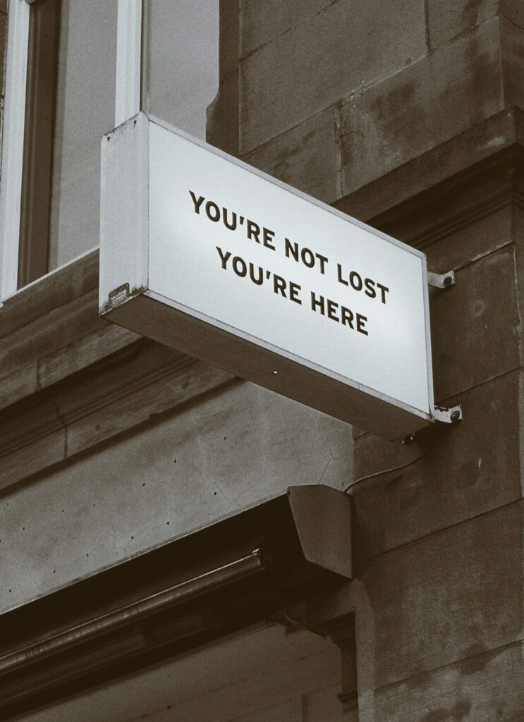 Foto van een bord dat zegt: You're not lost. You're here
